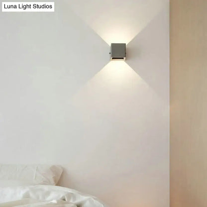 Minimalist black cement led wall lamp with a sleek square metallic body emitting warm focused light for living room
