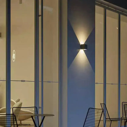 Minimalist black cement led wall lamp with two angled lights casting a warm glow for living room use