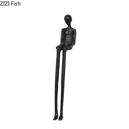 Minimalist black character metal statue of a slender seated humanoid as a metal statue desk ornament for living room