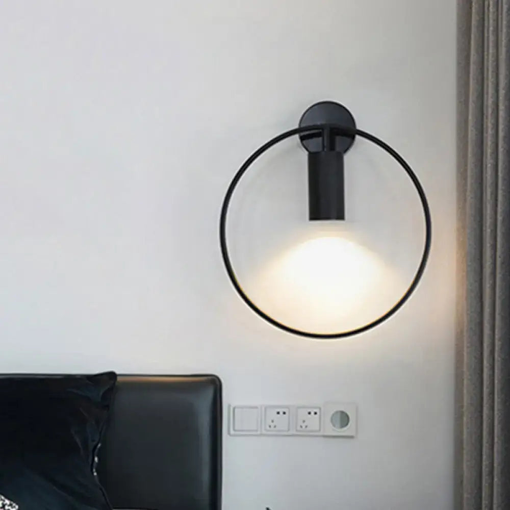 Minimalist black circular metal sconce with frosted glass diffuser for living room wall lighting