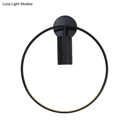 Minimalist black circular metal sconce with matte finish and gold accent for living room wall lighting