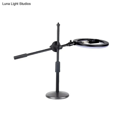 Minimalist black finish led ring light with magnifying glass and phone holder on articulated stand for bedroom vanity