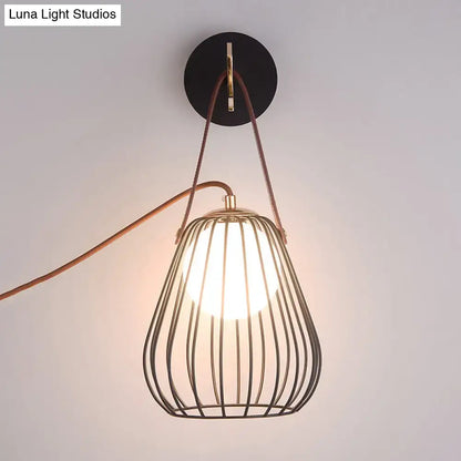 Minimalist black finish pear cage iron wall sconce with brass frame and brown leather straps for bedroom lighting