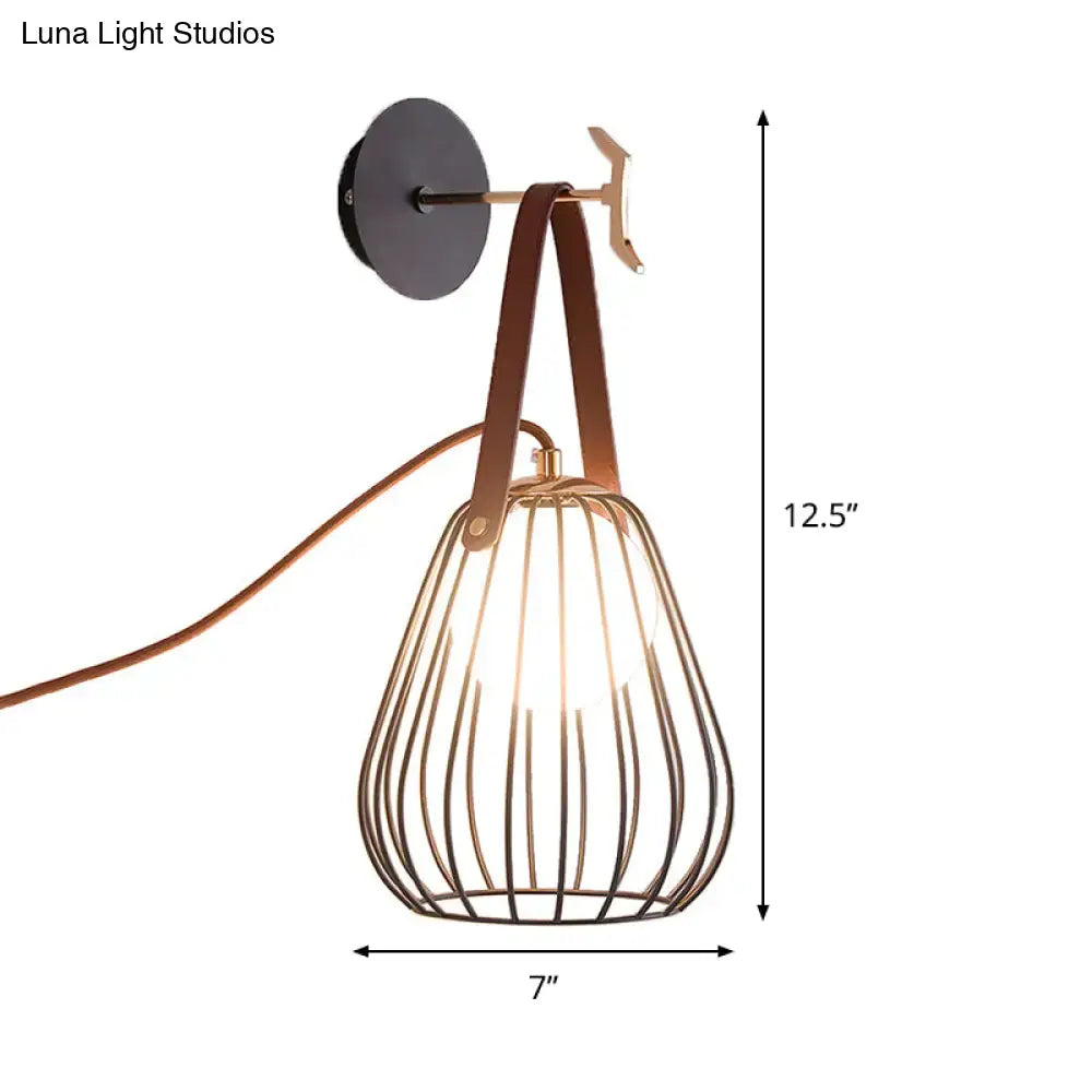 A modern wall-mounted lamp with black finish pear cage iron and teardrop-shaped shade with brown leather straps