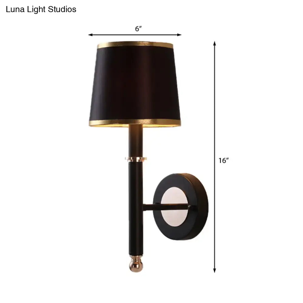 Minimalist black flaxen sconce light with drum-shaped shade and gold trim on black metal arm for 110v-120v 220v-240v use