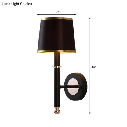 Minimalist black flaxen sconce light with drum-shaped shade and gold trim on black metal arm for 110v-120v 220v-240v use