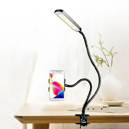 Black flexible arm gooseneck desk lamp with phone holder clamp for minimalist bedroom use