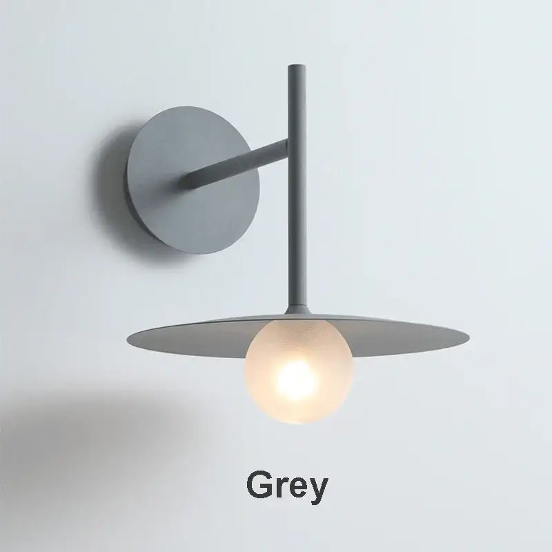 Minimalist black flying saucer wall lamp with grey circular base, slender arm, and frosted glass bulb for bedroom decorbites flying saucer wall lamp