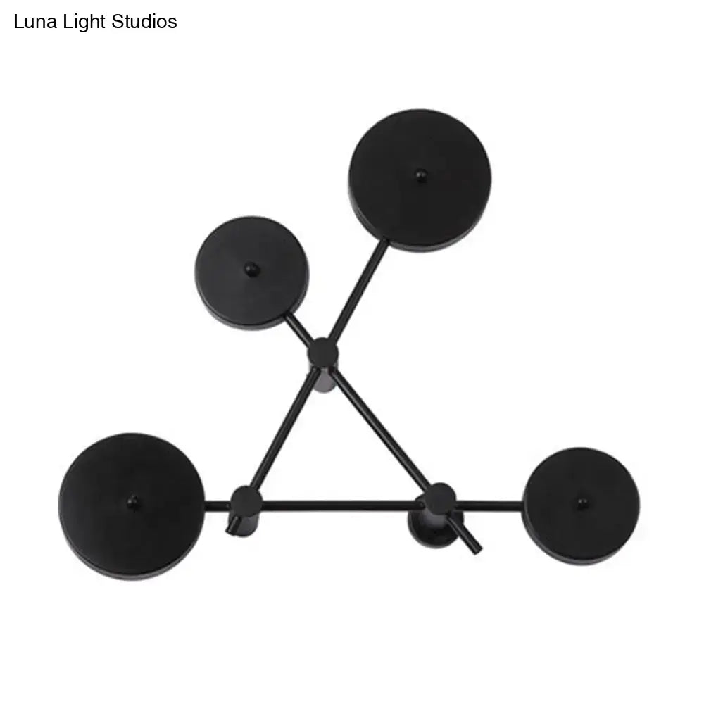 Minimalist black geometric wall light fixture with five circular lights arranged in a triangular pattern for living room