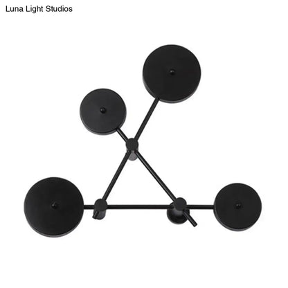 Minimalist black geometric wall light fixture with five circular lights arranged in a triangular pattern for living room