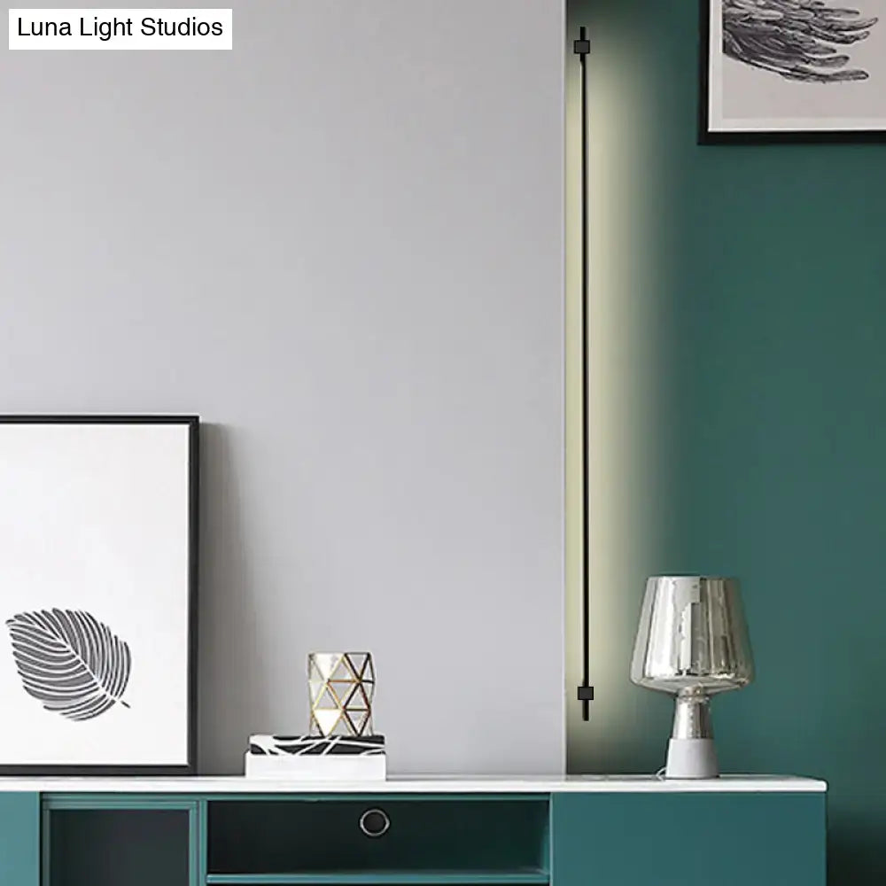 Minimalist black and gold feather wing wall light with slim led strip and soft green illumination for living room