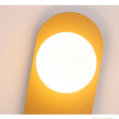 Modern yellow wall sconce with circular illuminated center and smooth edges from decorbites glass ball led collection