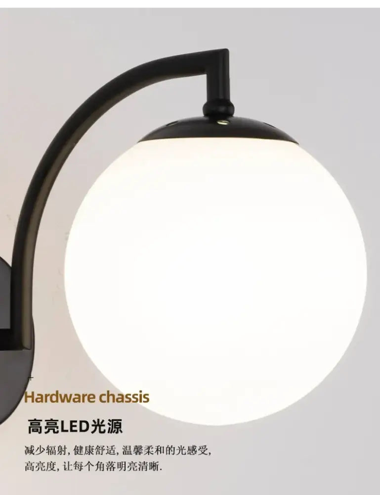Black curved arm holding minimalist black and gold decorbites glass ball wall light with frosted spherical lamp