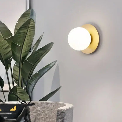 Gold-toned circular led wall lamp with frosted glass globe for living room minimalist black and gold wall sconce
