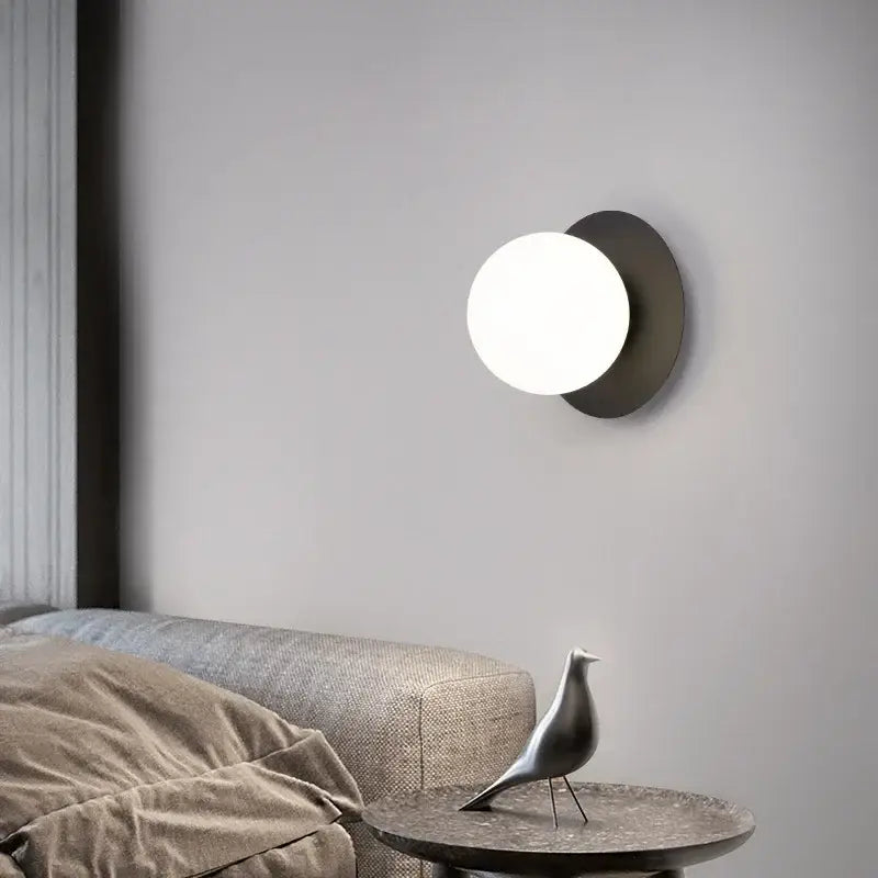 Minimalist black and gold led wall lamp with matte black base and glowing white spherical globe for living room wall lamp