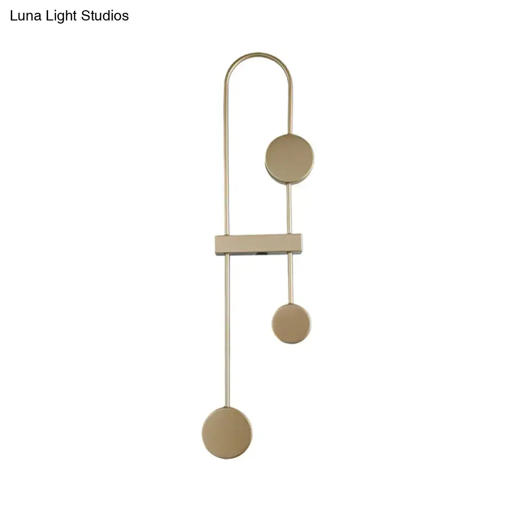 Modern black gold metal led wall sconce with three circular discs and rectangular bar suspended by slender rods