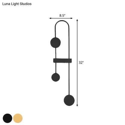 Minimalist black and gold metal led wall sconce with three spherical bulbs and a central rectangular bar for bedroom lighting