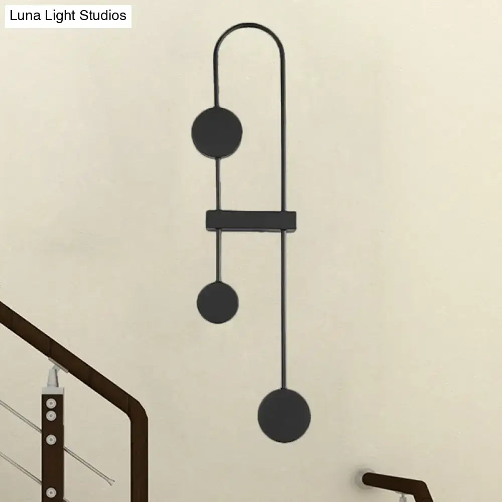 Black gold minimalist metal led wall sconce with sleek curved arms and three circular discs for bedroom lighting