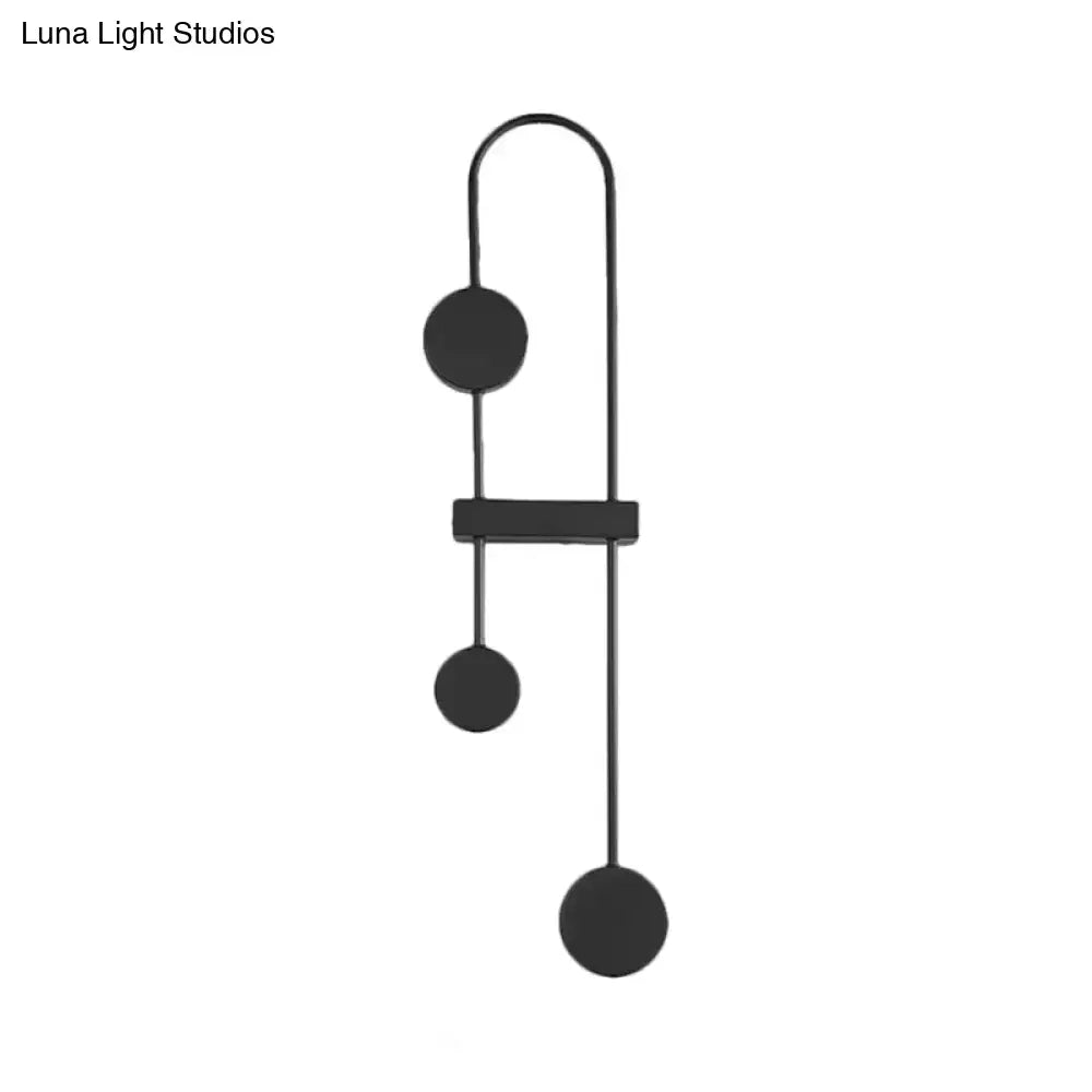 Minimalist black gold metal led wall sconce with sleek curved arms and three matte circular shades for bedroom light