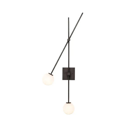 Minimalist black metal wall sconce with two frosted opal glass bubble shades and gold metal arms for bedroom light fixture