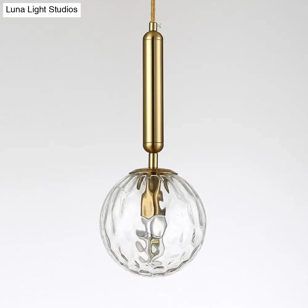 Minimalist black gold spherical wall sconce with clear textured glass globe and brass 10 inch fixture for bedroom