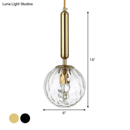 A clear textured glass globe pendant light with black gold brass finished inch fixture for minimalist bedroom use