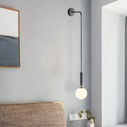 Minimalist black gold spherical wall sconce with frosted glass globe and sleek curved arm 10 inch fixture for bedroom