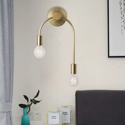 Brass-toned minimalist black and gold wall lamp with two curved arms and exposed filament bulbs for bedroom use