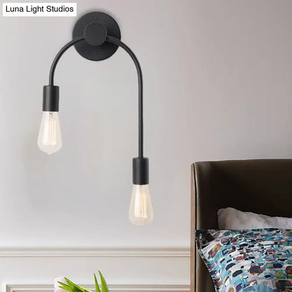 Minimalist black and gold metal wall lamp with two curved arms holding exposed filament bulbs for bedroom use