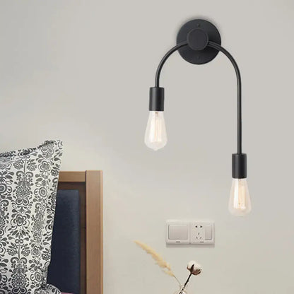 Minimalist black and gold double arm wall lamp with exposed filament bulbs for bedroom lighting