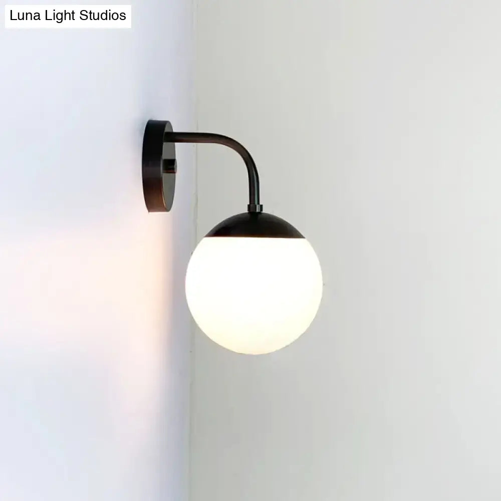 Black metal wall light featuring a minimalist golden black design with a milky glass ball for bedroom use