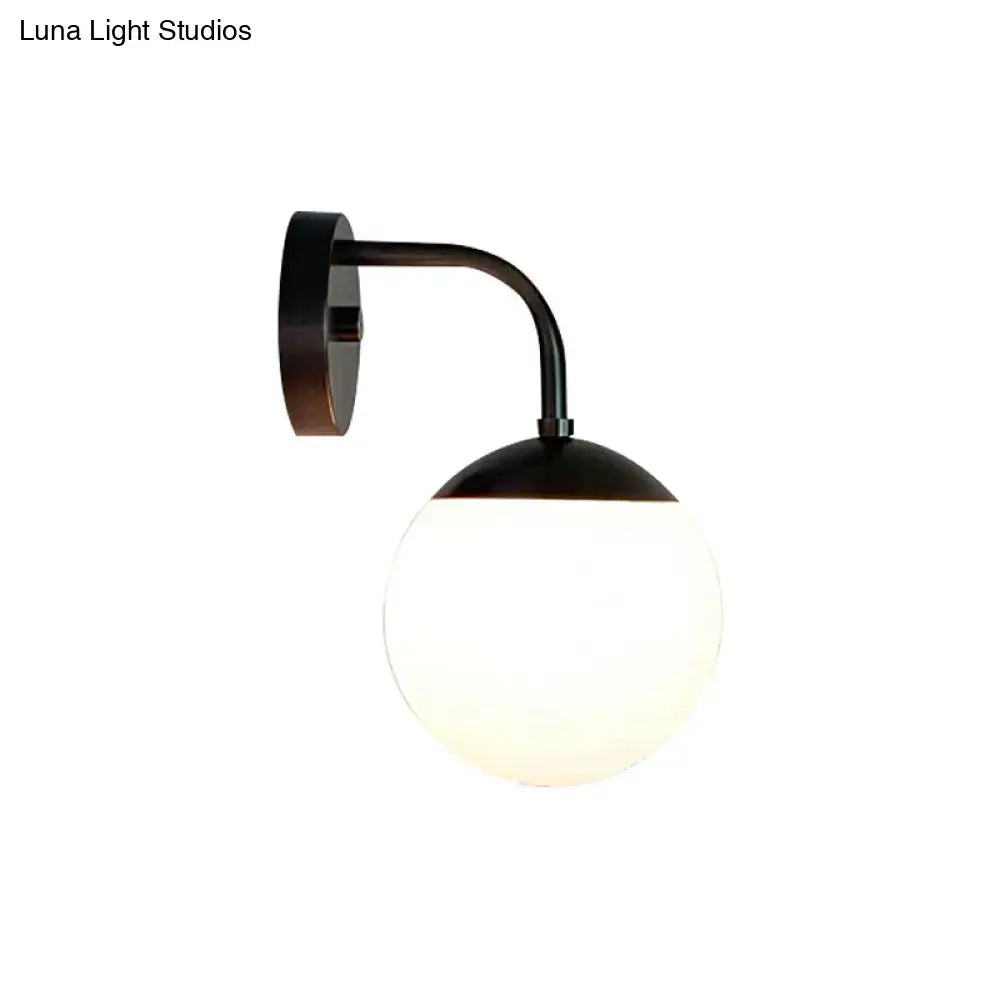 Black metal wall light with minimalist golden black finish and frosted milky glass ball for bedroom lighting