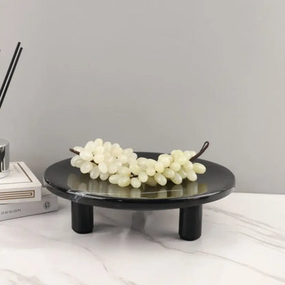 Minimalist black imitation marble fruit tray with two legs holding white faux grapes for dining room decorbites imitation marble