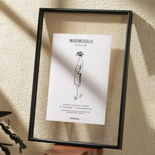 Black-framed minimalist hangable picture frame featuring chanel mademoiselle privé line drawing art on white paper