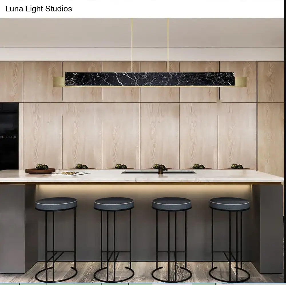 Minimalist black marble rectangular pendant light with gold accents and gold metal details hanging from black cord