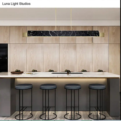 Minimalist black marble rectangular pendant light with gold accents and gold metal details hanging from black cord