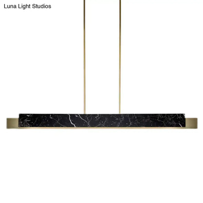 Minimalist black marble rectangular pendant light with gold metal accents and black cord for dining room use