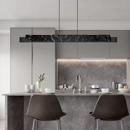 Minimalist black marble linear pendant light with gold accents and black cord for modern dining room lighting