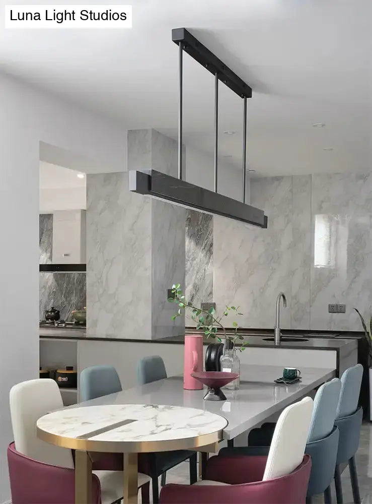 Minimalist black marble rectangular dining room light with gold accents and black cord featuring sleek metallic rods