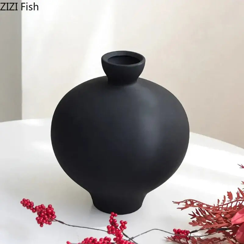 A sleek matte black big belly ceramic vase with rounded body and narrow neck for minimalist living room decor
