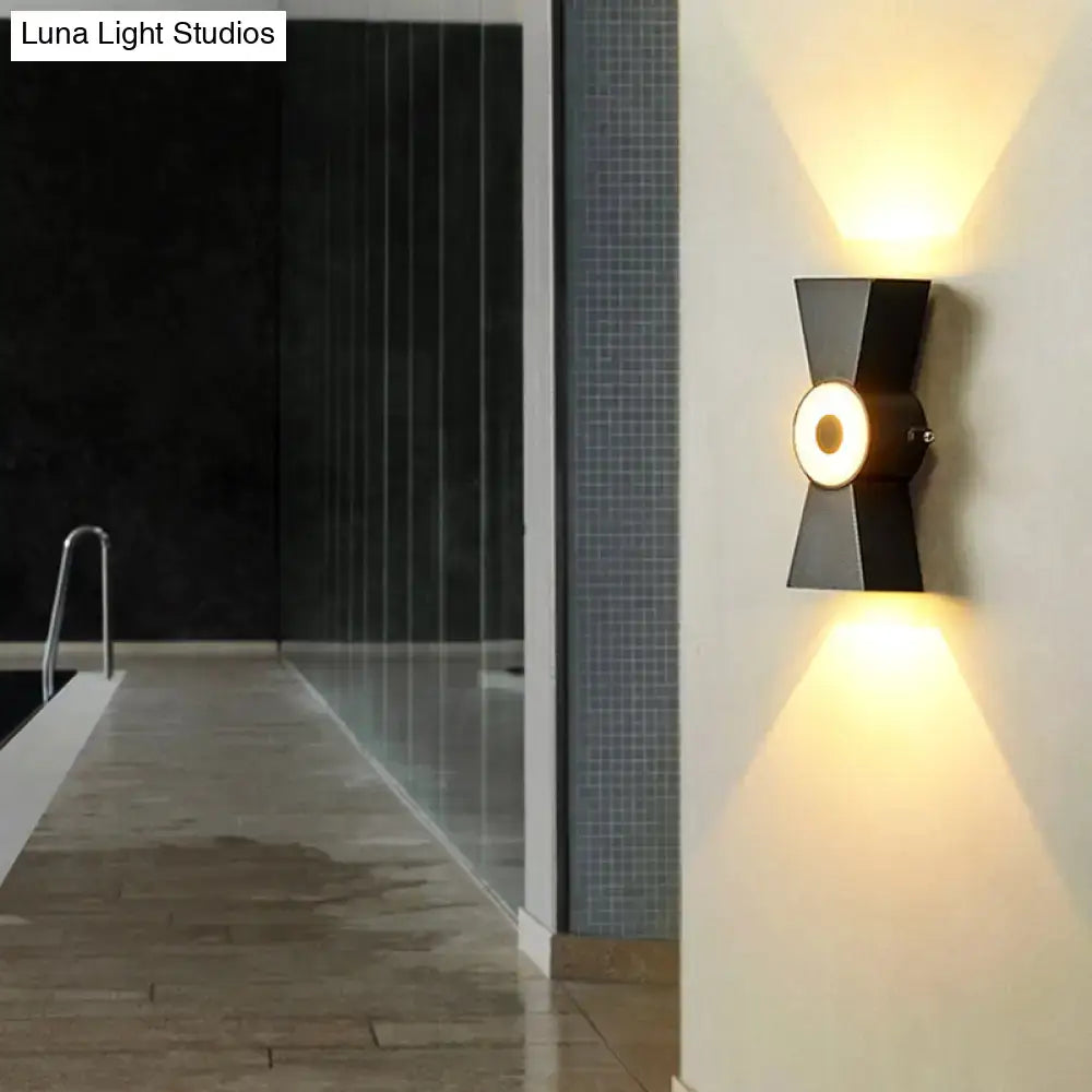 Modern black metal wall sconce with warm white light and geometric design for minimalist bedroom fixtures