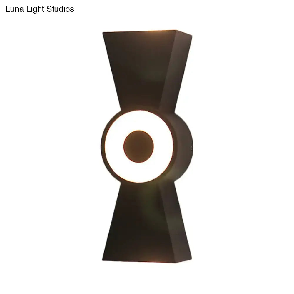 Minimalist black metal wall sconce with geometric bow silhouette and warm white light for bedroom use