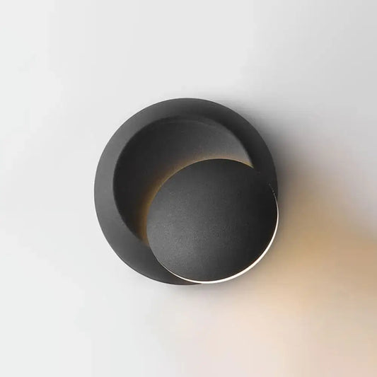Minimalist black moon shaped sconce lighting with matte finish designed as a bedroom wall lamp