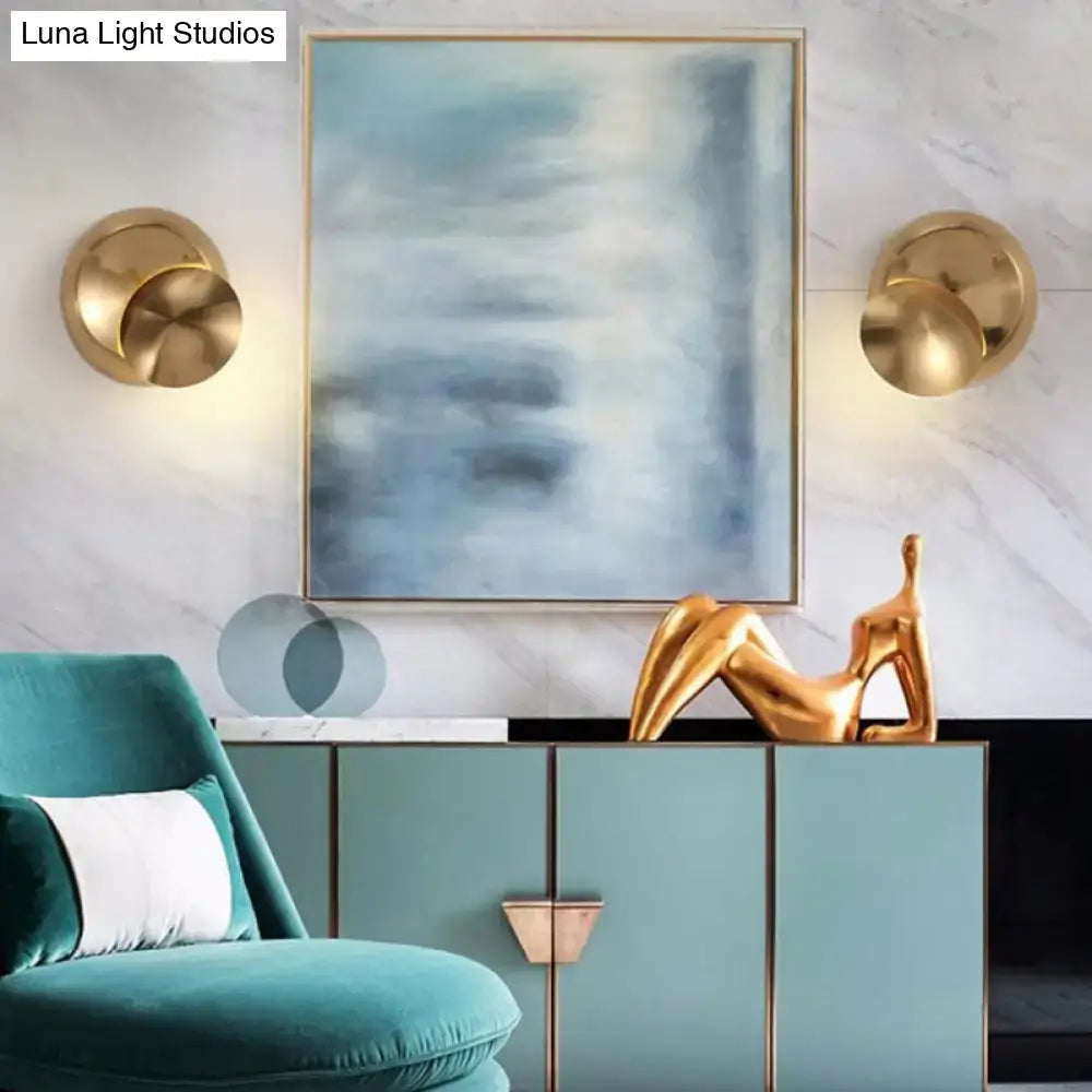 Gold abstract sculpture of reclining figure on teal cabinet next to minimalist black moon shaped sconce lighting bedroom lamp
