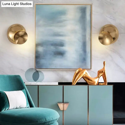 Gold abstract sculpture of reclining figure on teal cabinet next to minimalist black moon shaped sconce lighting bedroom lamp