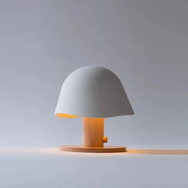 Minimalist black mushroom glass table lamp with matte white ceramic dome and wood base emits warm glow decorbites glass table lamp