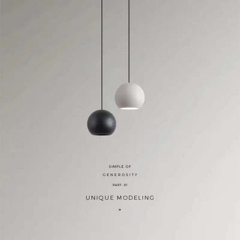 Two minimalist spherical die-cast aluminum pendant lights in matte black and off-white with acrylic lamp holders for kitchen use