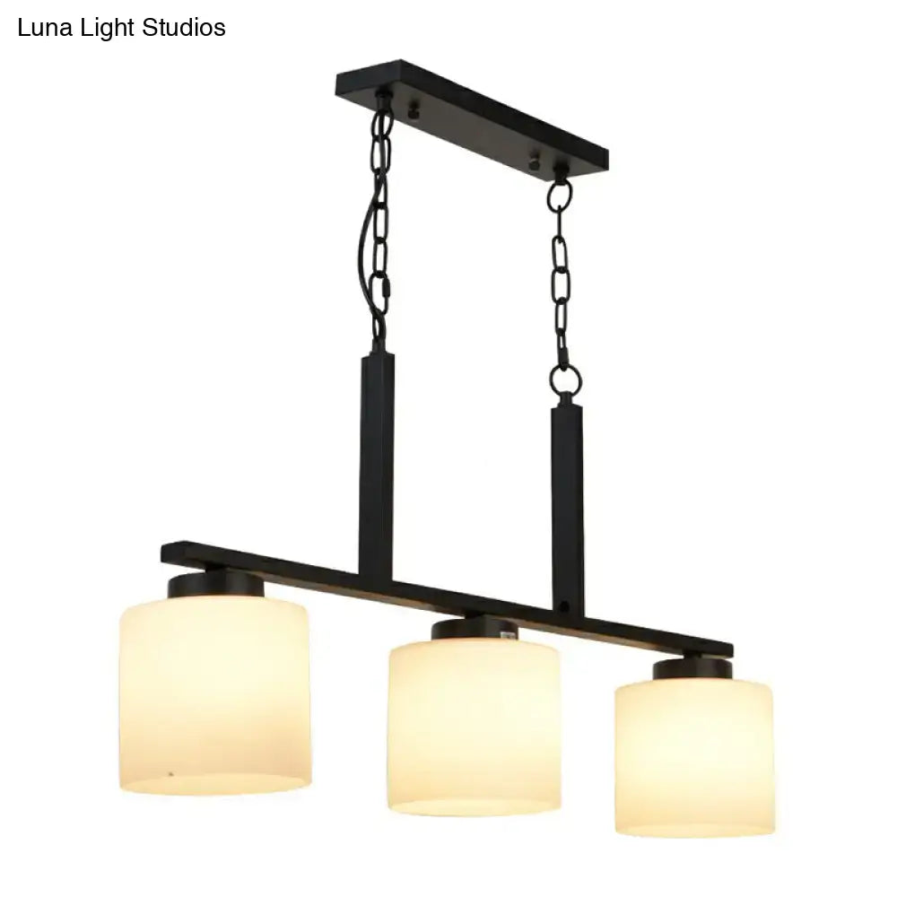 Black metal pendant light with three opal frosted glass shades for minimalist island lighting fixture by DecorBites