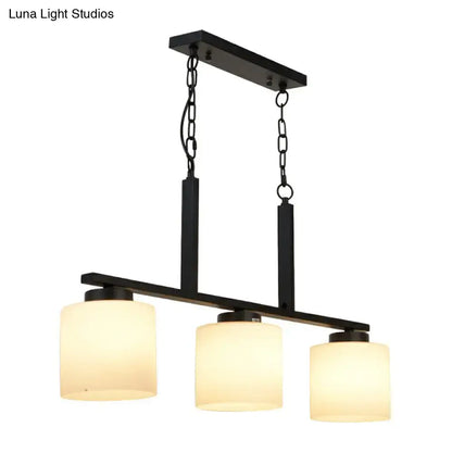 Black metal pendant light with three opal frosted glass shades for minimalist island lighting fixture by DecorBites