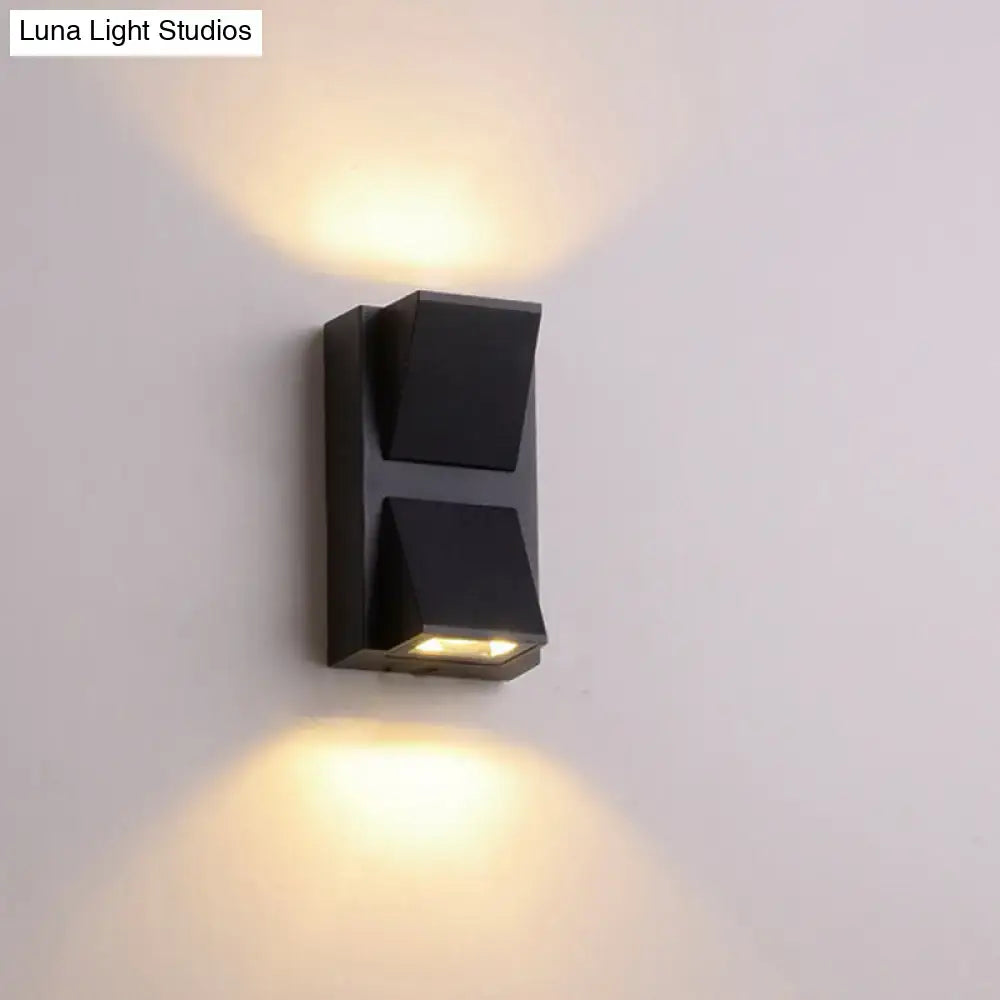 Minimalist black triangle aluminum flush wall lamp with two angled fixtures emitting warm ambient corridor light
